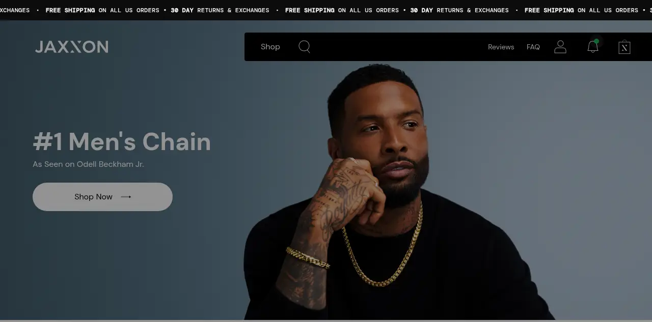 Man wearing a gold chain and black shirt against a gray background