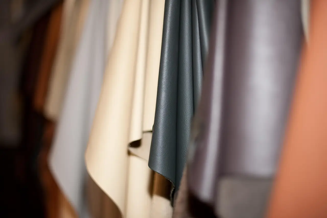 Assorted leather fabric swatches hanging in a row with varied colors and textures