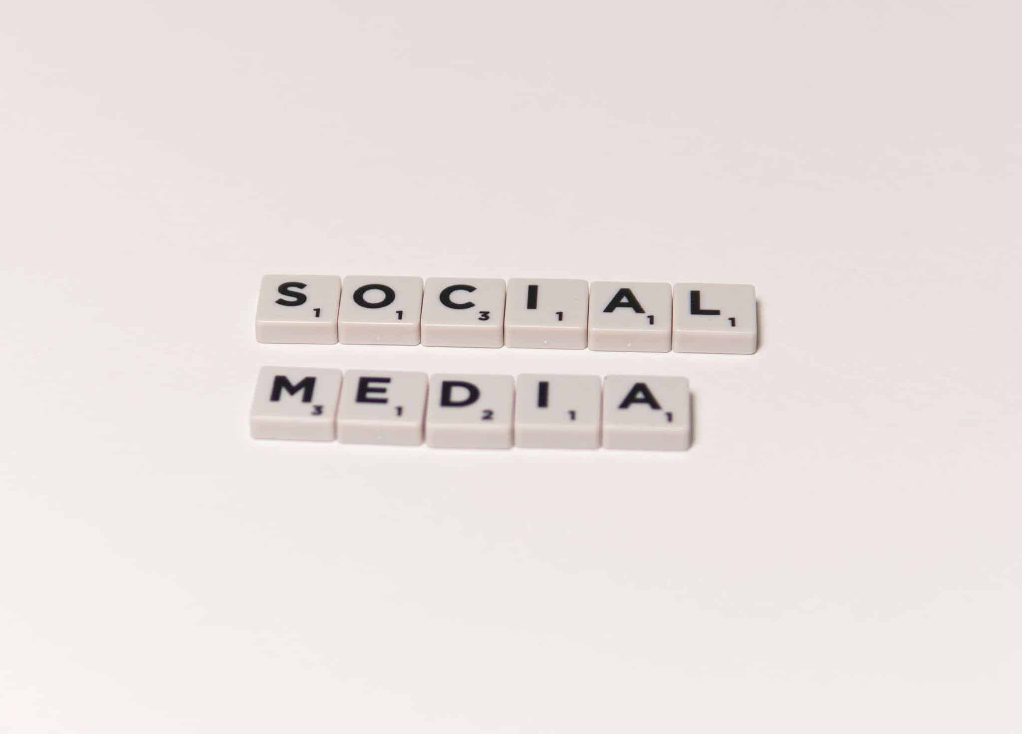 Scrabble tiles spelling "social media" on a plain white background