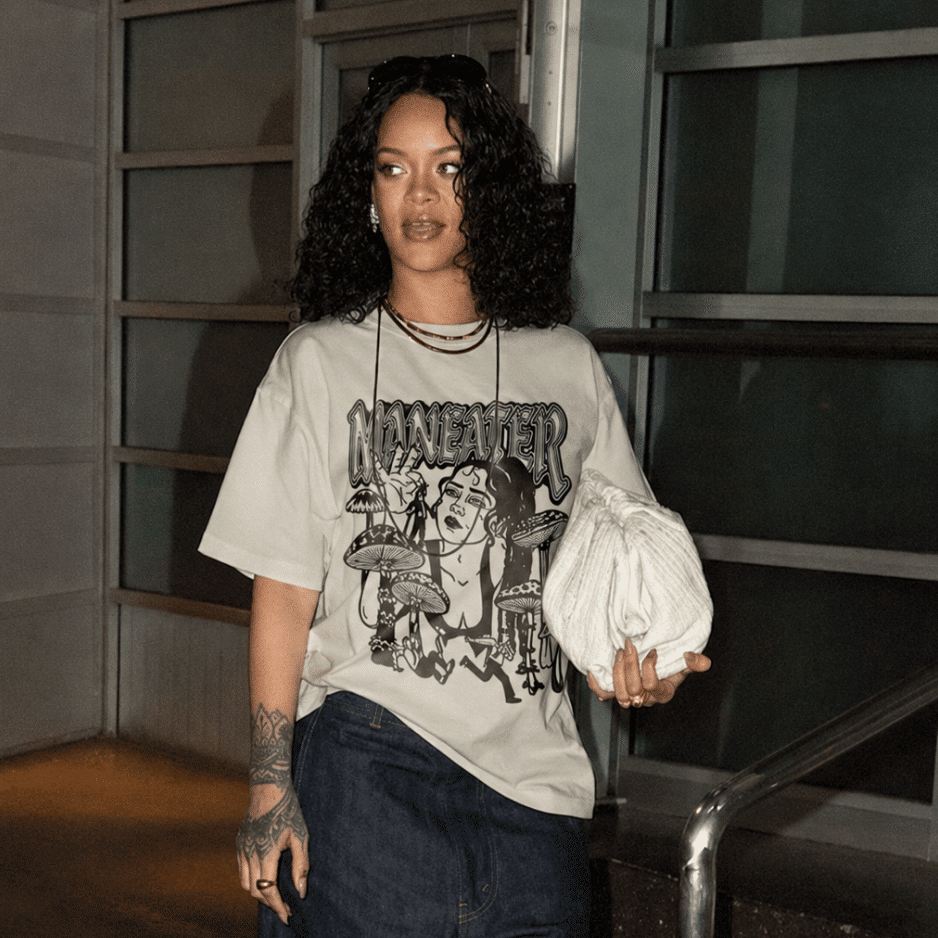 Rihanna wearing an oversized graphic T-shirt with dark jeans, showcasing casual retro fashion trends.