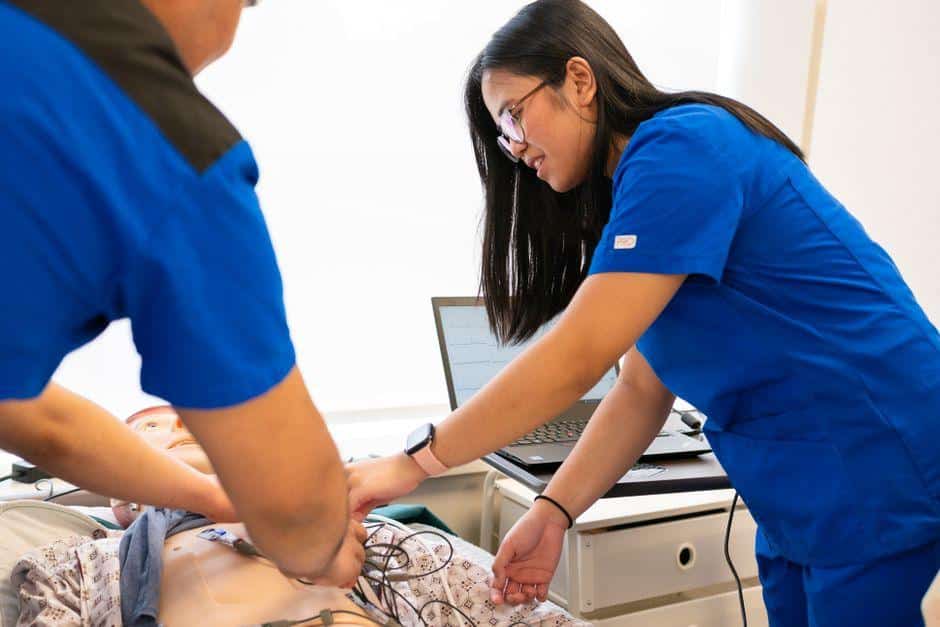 Medical students practicing CPR on a training manikin in a clinical lab setting