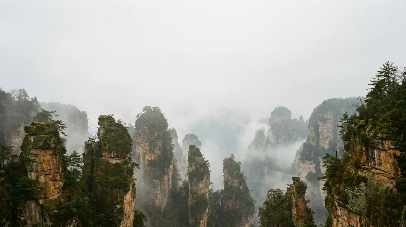 Misty mountain peaks covered with lush green trees in a foggy landscape