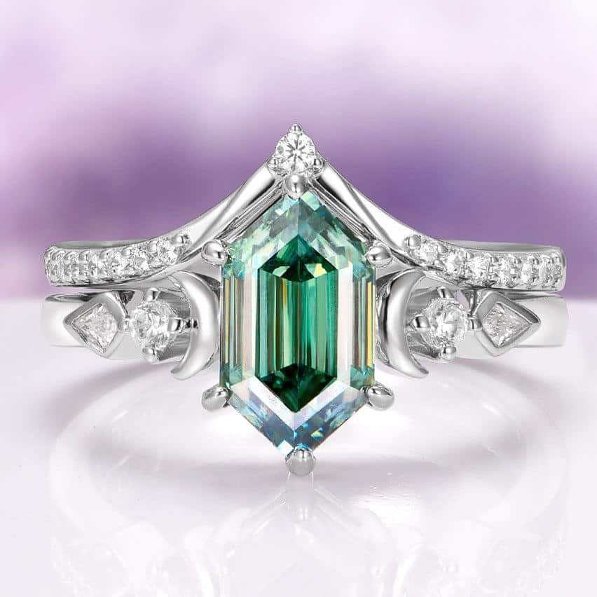 Silver ring with large emerald cut green gemstone and small diamonds on lavender background
